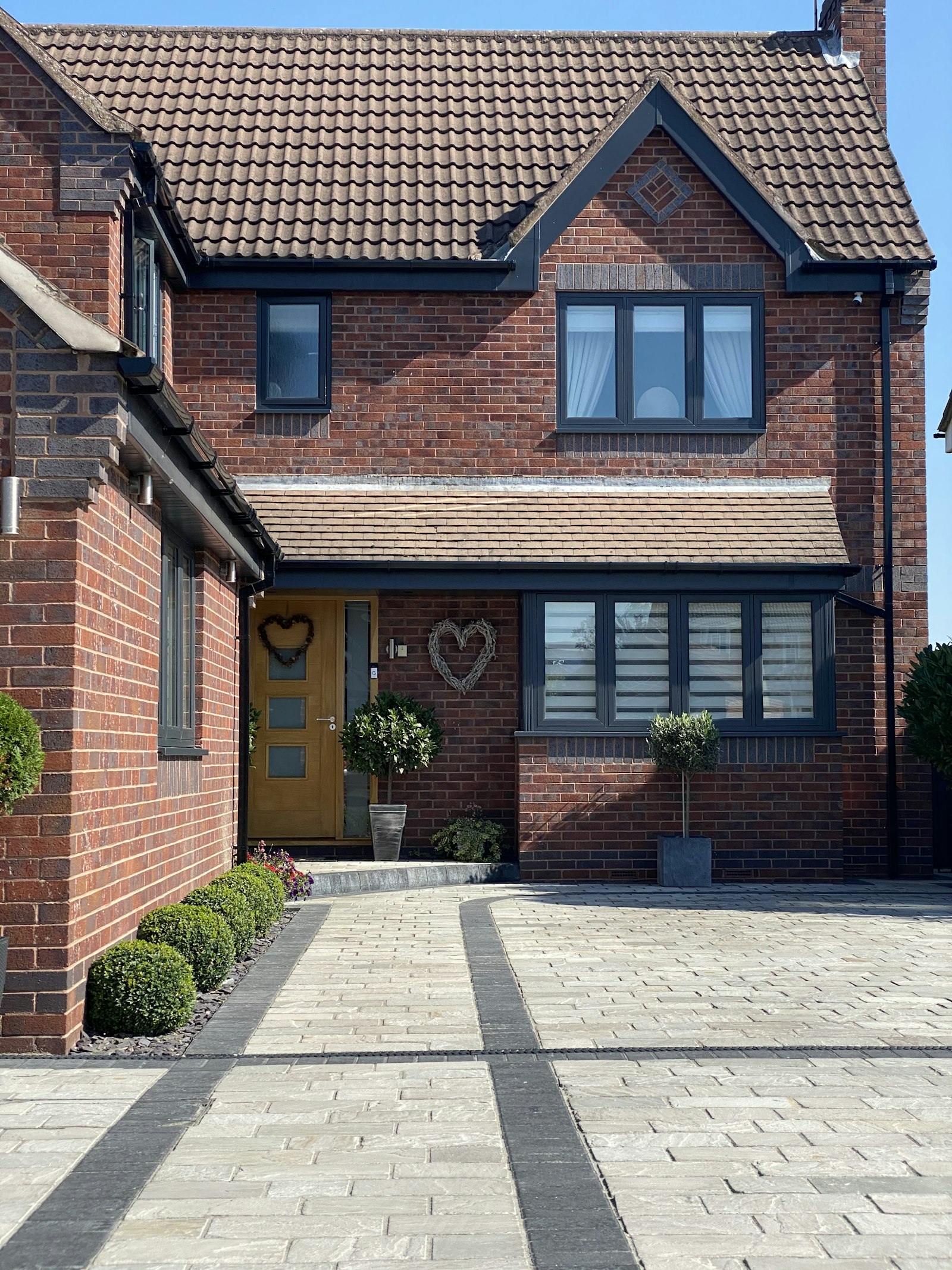 Red-brick British house with modern anthracite windows